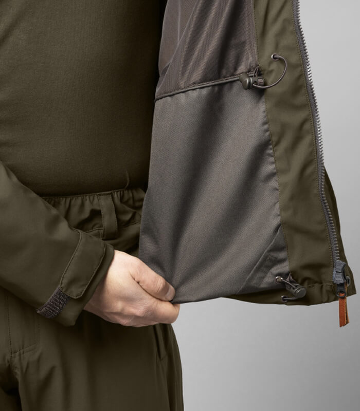 A classic hunting jacket made from a soft and stretchy fabric ehich is fitted with a HWS® waterproof membrane. It has a practical packable hood. There are handwarmer pockets and large front pockets with quick-load straps. There is also a Napoleon pocket and an inside pocket. The fit can be adjusted with drawstrings at the waist and lower hem. The jacket has a classic fit.